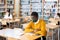 Man in mask studying in public library