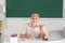 Man mature teacher. Portrait of happy senior tutor in glasses with book on the blackboard in class at high school or