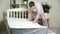 A man measures the length of a mattress with a tape measure.