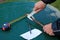 Man measures metal rod diameter with caliper.