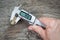 Man measuring caliper detail on a wooden .