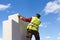 Man measuring chimney on roof top of new house under construction