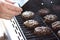 Man measuring temperature of burger cooking on the grill