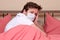 Man in medical mask on bed desperate suffering depression or emotional crisis