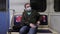 Man in medical mask enter the subway cabin sit on empty seat and read a message on the phone