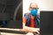 A man in a medical mask and glasses sits in front of monitors. Specialist works at the computer in an individual means of