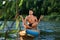 Man meditating on color SUP board on river