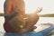 Man meditating on light blue SUP board on river at sunset, closeup