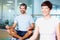 Man meditating in lotus position. Smiling man meditating in lotus position with woman in foreground.