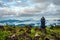 Man meditating on rock isolated at the serene nature with amazing cloud layers in foreground