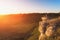 Man meditating at sunset sitting on rock at mountain background