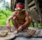 Man Mentawai tribe prepares poison for the arrows for hunting.