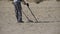 Man with a Metal Detector Walks along a Sandy Beach on the Seashore. Slow Motion