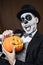 Man with mexican calaveras makeup and carved pumpkin