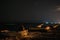 Man in the middle of the boats looks at the starry sky