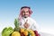 Man from the Middle East in a traditional Arab national costume, stands in front of a mountain of fresh fruit, joyfully smiles and