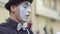 Man mime put on his hands white gloves