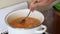 A man mixes chicken broth with vegetables. Sorrel soup is boiled in a saucepan. Regional food