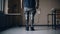 A man in modern prostheses of both legs stands in the room, rear view, modern prosthetics.