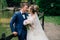 A man in a modern suit and a girl in a wedding dress embrace and bask in each other on their wedding day. The bride is