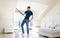 Man with mop and bucket cleaning floor at home