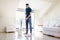 Man with mop and bucket cleaning floor at home