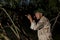 Man in mosquito net ready to hunt with hunting rifle