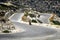 Man on motorbike rides on serpentine road at Crete island, Greece