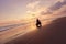 Man And Motorcycle On Ocean Beach At Beautiful Tropical Sunset. Biker Silhouette On Motorbike.