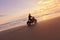 Man And Motorcycle On Ocean Beach At Beautiful Tropical Sunset. Biker Silhouette On Motorbike.