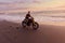 Man And Motorcycle On Ocean Beach At Beautiful Tropical Sunset. Handsome Biker On Motorbike.