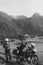 Man motorcyclist Looking for something in the trunk. Alpine mountains on background. Biker lifestyle, world traveler. Summer day.