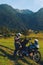 Man motorcyclist Looking for something in the trunk. Alpine mountains on background. Biker lifestyle, world traveler. Summer sunny