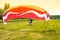 Man with motorized paraglider takes off from a field