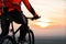 Man on mountain bike rides on the trail on a beautiful sunset. Bicycle wheel closeup.