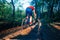 Man on mountain bike rides on the trail through the woods while moving extremely fast
