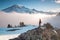 Man on the mountain peak looking on mountain valley with low clouds at colorful sunrise in autumn in Mount Rainier National park.