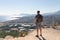 The man on a mountaintop admiring the surrounding mountain landscape