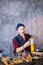 Man with moustache, cap, vest and shirt preparing tools for melting golden items