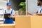 Man mover worker in blue uniform checking lists on clipboard while unloading cardboard boxes from truck.Professional delivery and