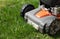 Man moves with lawnmower mows green grass