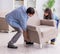 Man moving armchair in the living room