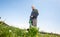 Man mowing, cutting grass on his huge garden yard, green field by the motor garden mower, gardening concept