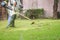 Man mowing the grass with portable machine in the garden