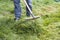 Man mowing the overgrown lawn. Man with electric lawn mower . Country life.