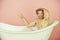 Man with muscular body sitting in white bathtub