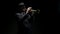 Man musician in hat and formal suit plays trumpet on black background, front view. Jazz performer plays trumpet in