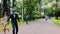 Man with mustache in dinner jacket sunglasses ride on skateboard on road in park