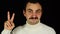 Man with mustache making victory sign over black background