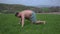 a man with a naked torso, doing exercises on the grass